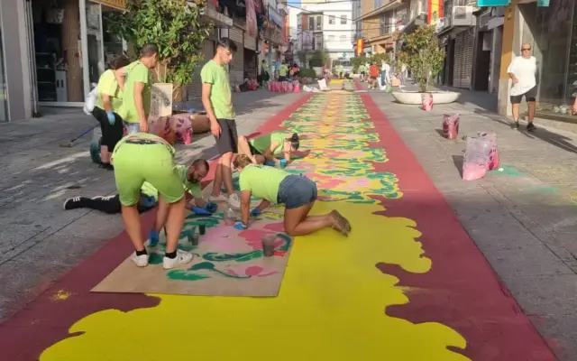 Voluntarios elaborando alfombras de sal coloreada en la calle Calzada de Puertollano