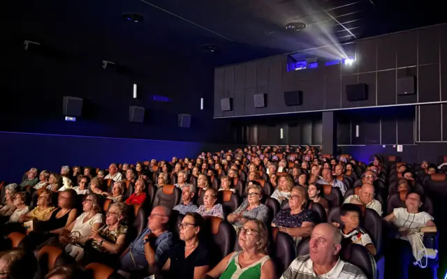 Personas mayores y familiares asisten a la proyección de cine en Multicines Cinemancha durante la Semana de los Mayores de Alcázar de San Juan
