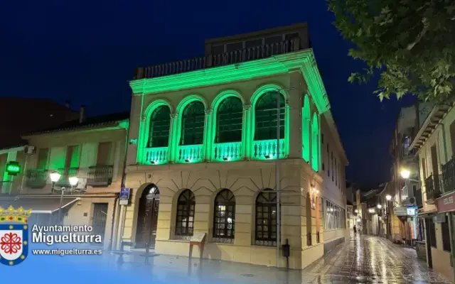 Fachada del Centro de Día de Miguelturra iluminada de verde con motivo del Día Nacional de la Artritis